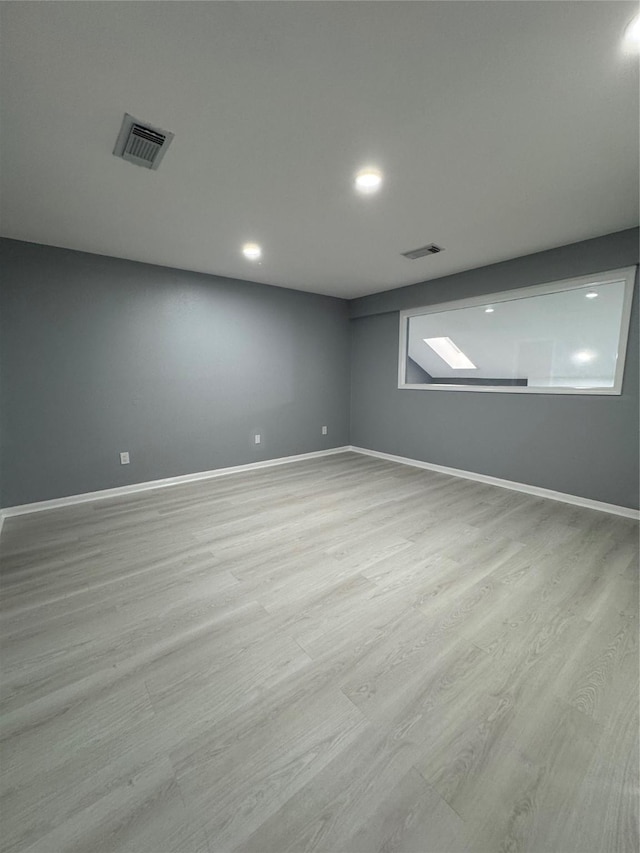 basement with light hardwood / wood-style flooring