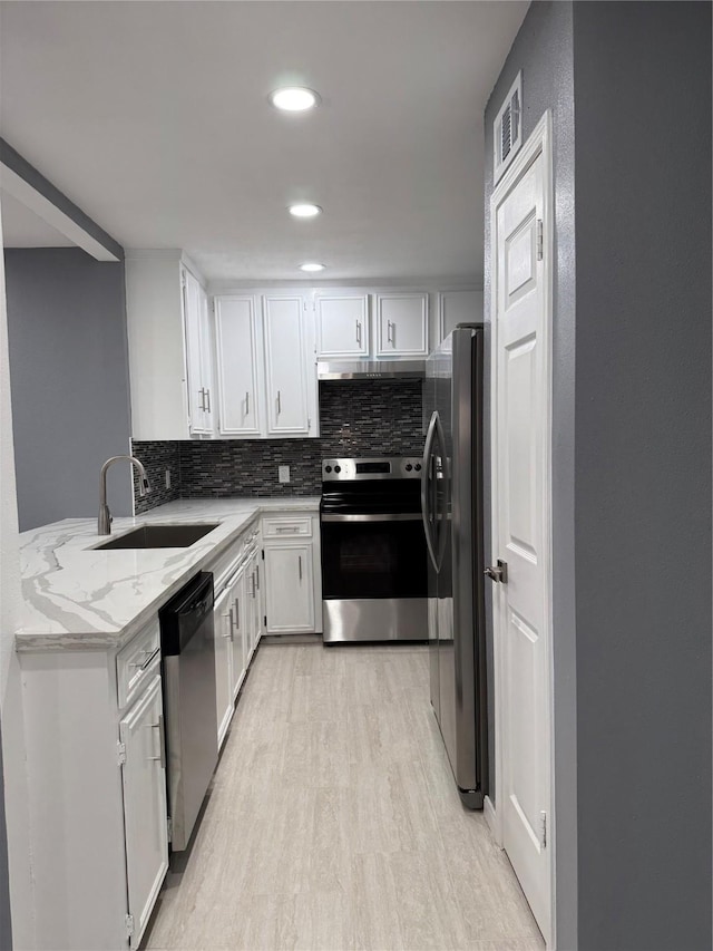 kitchen featuring white cabinetry, light stone countertops, and appliances with stainless steel finishes