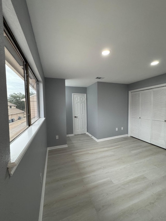 unfurnished bedroom with light hardwood / wood-style floors and a closet