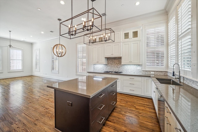 kitchen with hanging light fixtures, light stone countertops, sink, and white cabinets