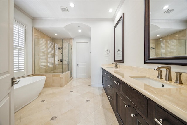 bathroom with tile patterned flooring, crown molding, separate shower and tub, and vanity