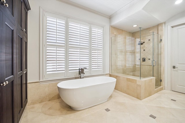 bathroom featuring crown molding, shower with separate bathtub, tile patterned flooring, and tile walls