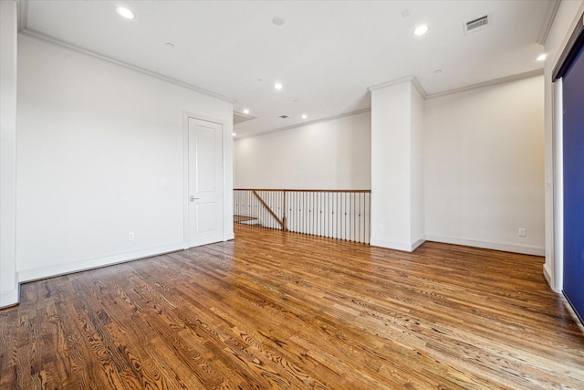 spare room with hardwood / wood-style floors and crown molding