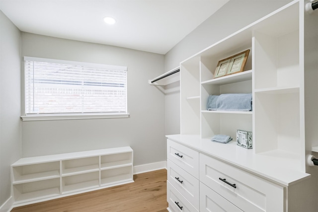 walk in closet with light hardwood / wood-style flooring