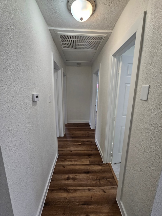 hall featuring dark hardwood / wood-style flooring and a textured ceiling