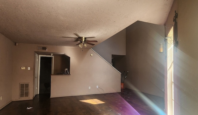 unfurnished living room featuring ceiling fan and a textured ceiling