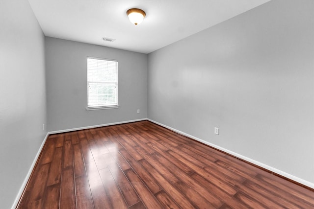 unfurnished room with dark wood-type flooring