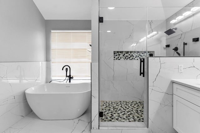 bathroom featuring vanity, shower with separate bathtub, and tile walls