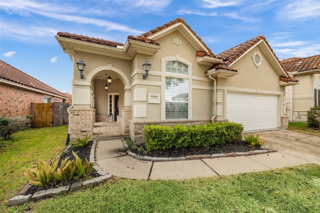 mediterranean / spanish home featuring a garage and a front lawn