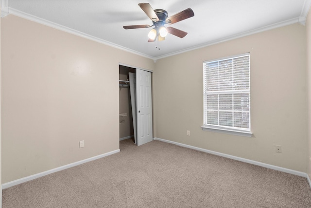 unfurnished bedroom with crown molding, light colored carpet, ceiling fan, and a closet