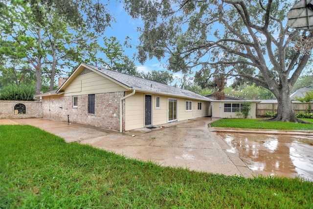 back of property featuring a lawn and a patio