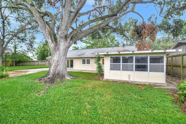 back of property featuring a yard and a sunroom