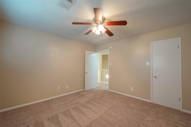 carpeted spare room featuring ceiling fan and a textured ceiling