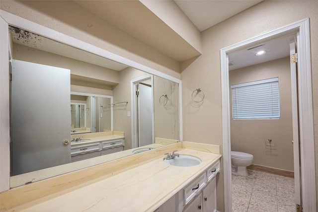 bathroom with vanity, toilet, tile patterned flooring, and a shower