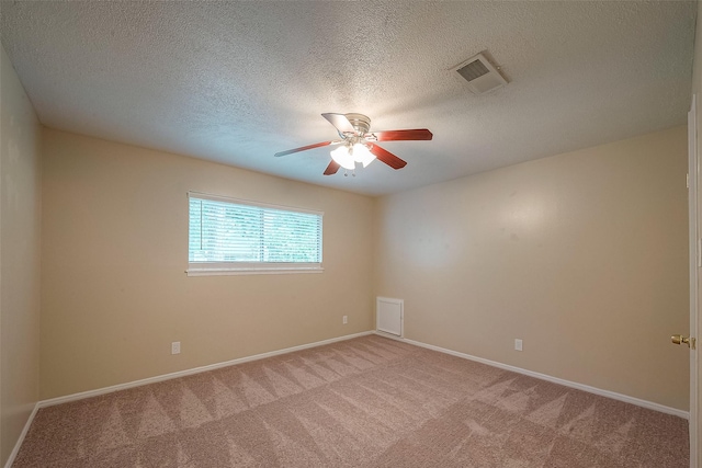 carpeted spare room featuring a textured ceiling and ceiling fan