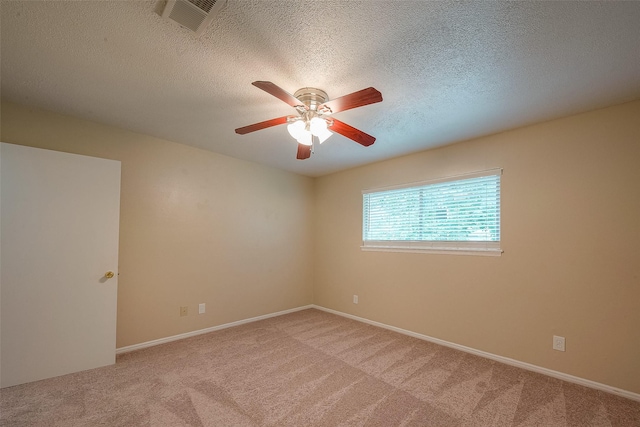 carpeted empty room featuring ceiling fan and a textured ceiling