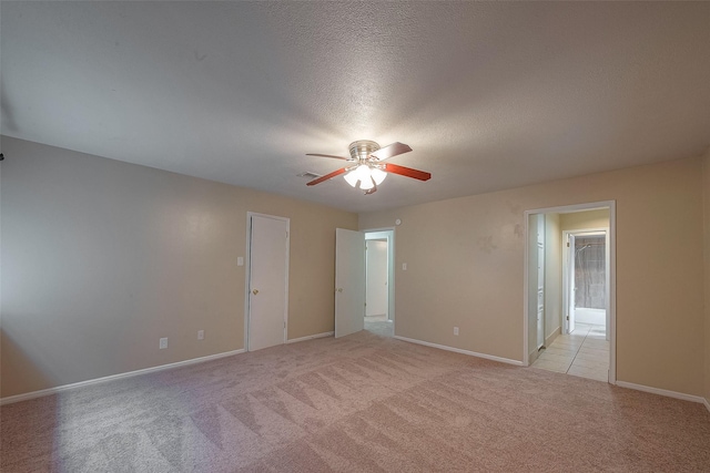 carpeted spare room featuring ceiling fan and a textured ceiling