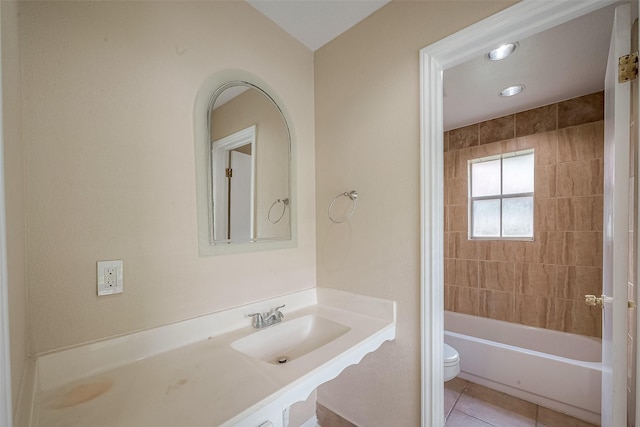 full bathroom featuring tiled shower / bath, tile patterned floors, toilet, and sink