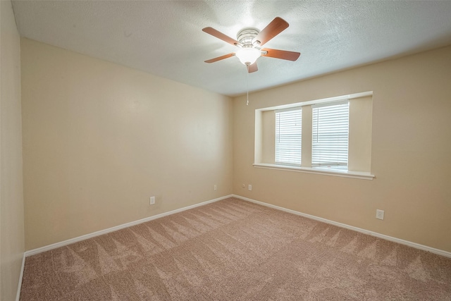 carpeted spare room featuring ceiling fan and a textured ceiling