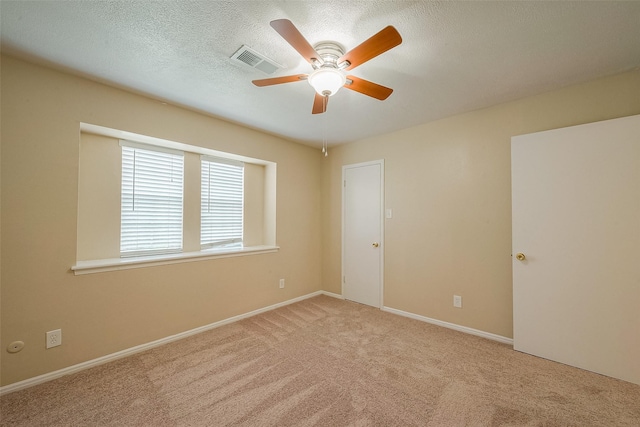 carpeted empty room featuring ceiling fan and a textured ceiling