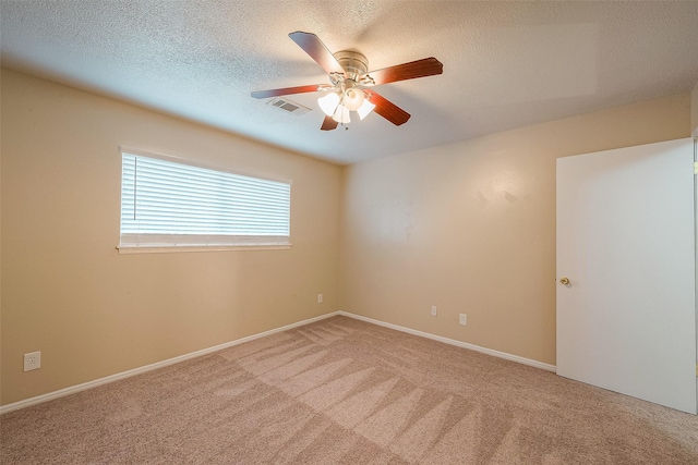 unfurnished room with ceiling fan, carpet flooring, and a textured ceiling