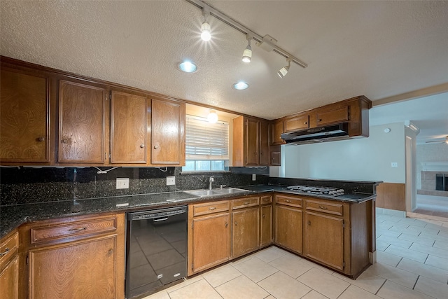 kitchen with light tile patterned flooring, sink, a textured ceiling, dark stone countertops, and dishwasher