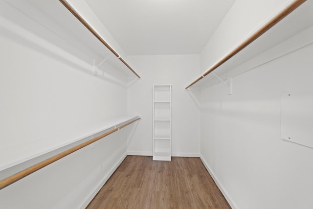 walk in closet with light hardwood / wood-style flooring