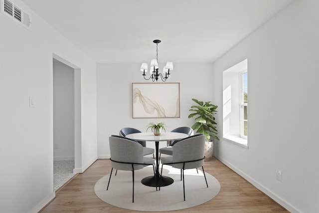 dining space with a notable chandelier and light wood-type flooring