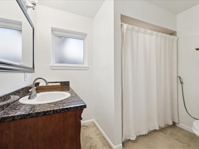 bathroom featuring vanity, curtained shower, and toilet