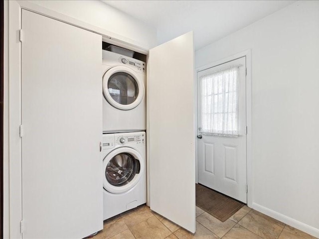 washroom with stacked washer and clothes dryer and light tile patterned flooring