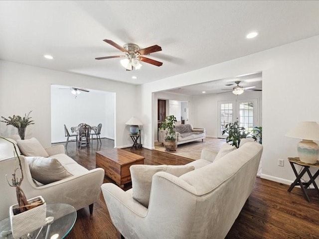 living room with ceiling fan and dark hardwood / wood-style flooring