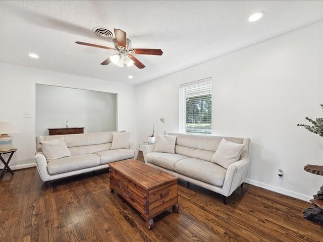 living room featuring dark wood-type flooring and ceiling fan