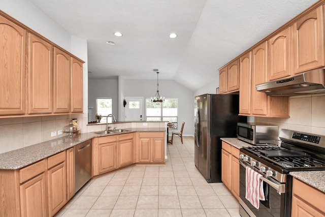 kitchen featuring appliances with stainless steel finishes, decorative light fixtures, lofted ceiling, sink, and kitchen peninsula