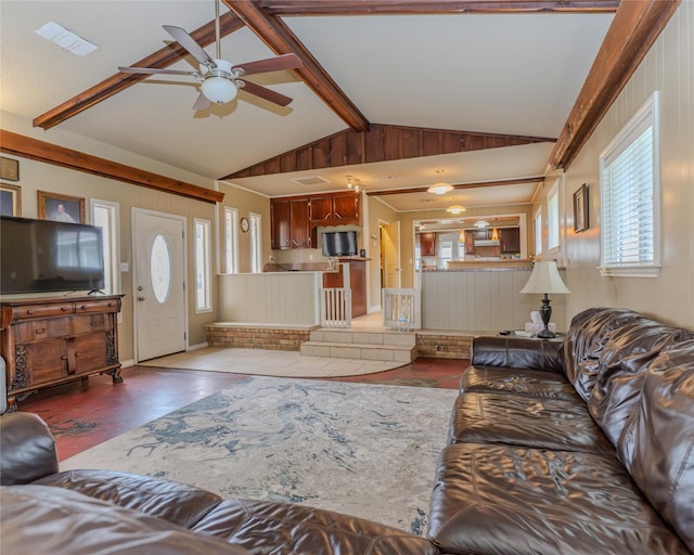 living room with vaulted ceiling with beams, a wealth of natural light, ceiling fan, and light wood-type flooring