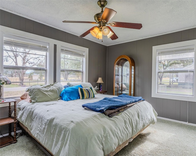 carpeted bedroom featuring a textured ceiling and ceiling fan