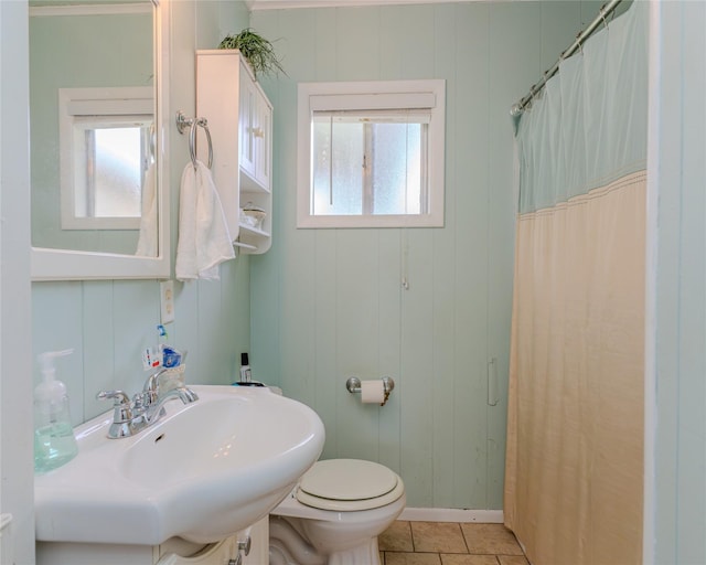 bathroom featuring tile patterned floors, a healthy amount of sunlight, toilet, and sink