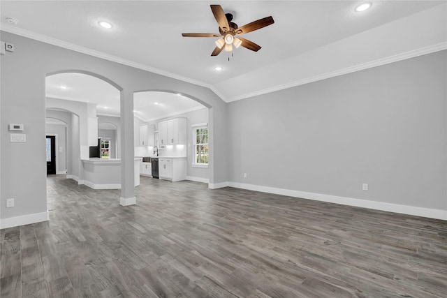 unfurnished living room featuring hardwood / wood-style flooring, lofted ceiling, ornamental molding, and ceiling fan