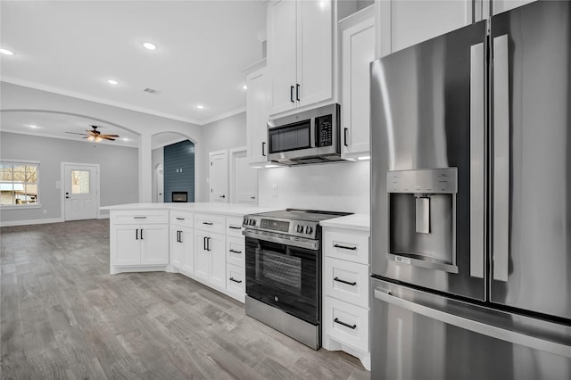 kitchen with white cabinetry, crown molding, light wood-type flooring, ceiling fan, and stainless steel appliances