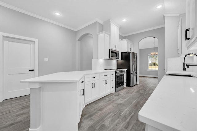 kitchen featuring a notable chandelier, appliances with stainless steel finishes, sink, and white cabinets