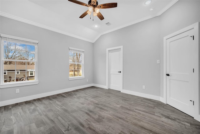 empty room with hardwood / wood-style flooring, ornamental molding, vaulted ceiling, and ceiling fan