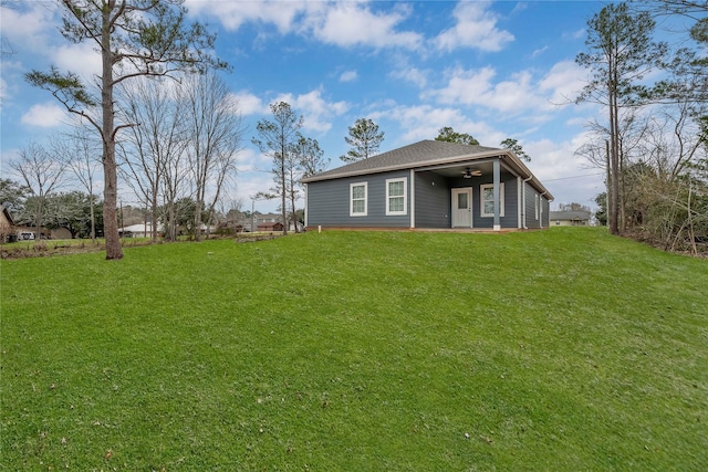 back of property featuring a ceiling fan and a lawn