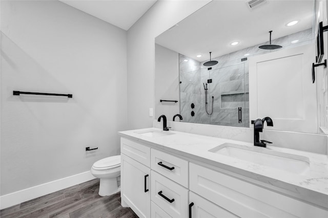 bathroom with wood-type flooring, toilet, a shower with shower door, and vanity