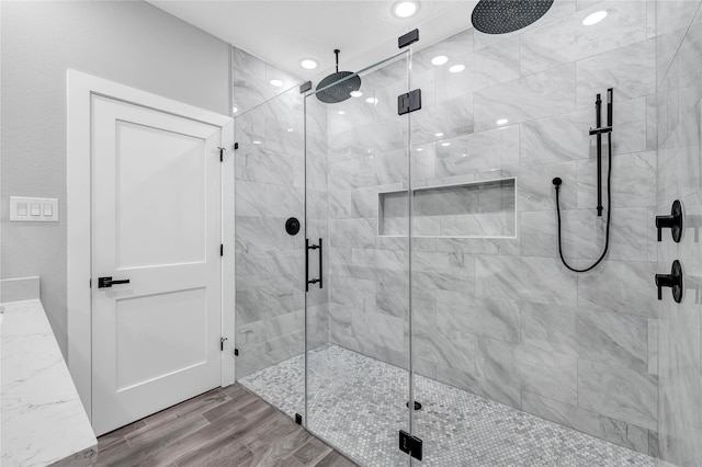 bathroom with hardwood / wood-style floors and a shower with shower door