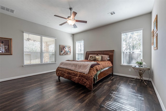 bedroom featuring ceiling fan, dark hardwood / wood-style flooring, and multiple windows