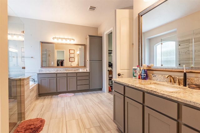 bathroom featuring vanity and shower with separate bathtub