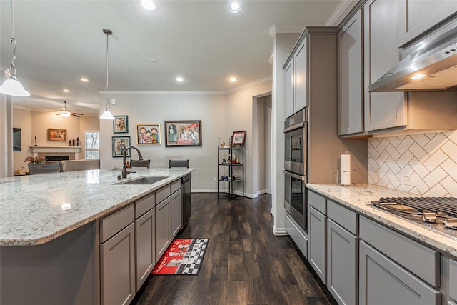 kitchen featuring dark wood-type flooring, sink, decorative light fixtures, ornamental molding, and decorative backsplash