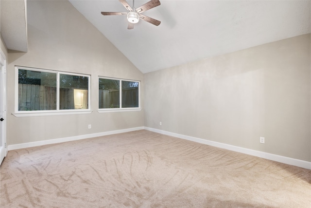 carpeted empty room with ceiling fan and high vaulted ceiling