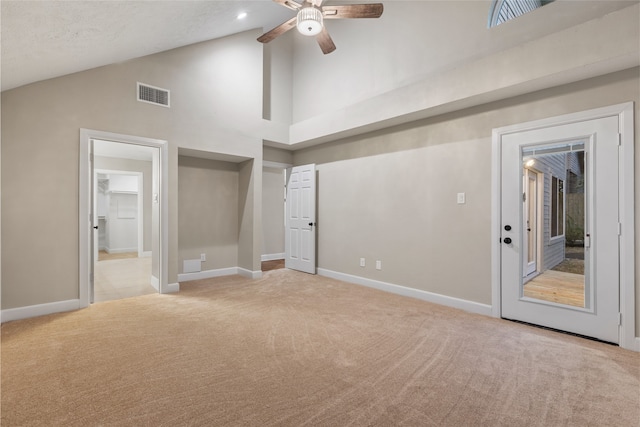 interior space featuring ceiling fan, light colored carpet, and high vaulted ceiling