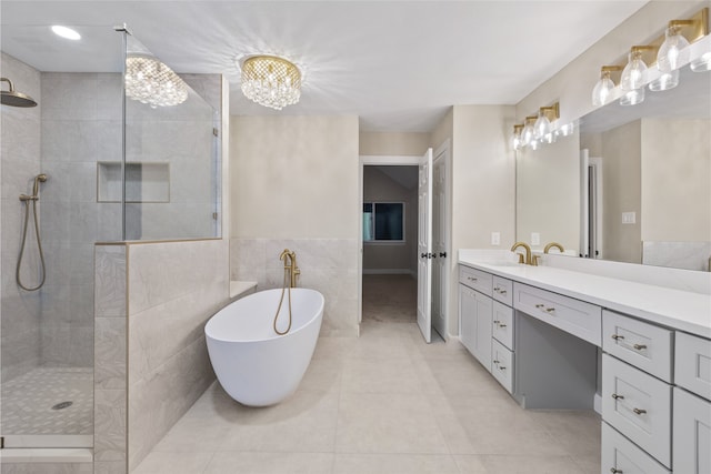 bathroom featuring tile patterned flooring, shower with separate bathtub, tile walls, and vanity