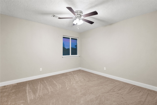 empty room featuring ceiling fan, a textured ceiling, and carpet flooring